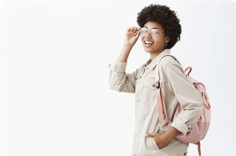 Une apprenante souriante, avec des lunettes et un sac à dos.
